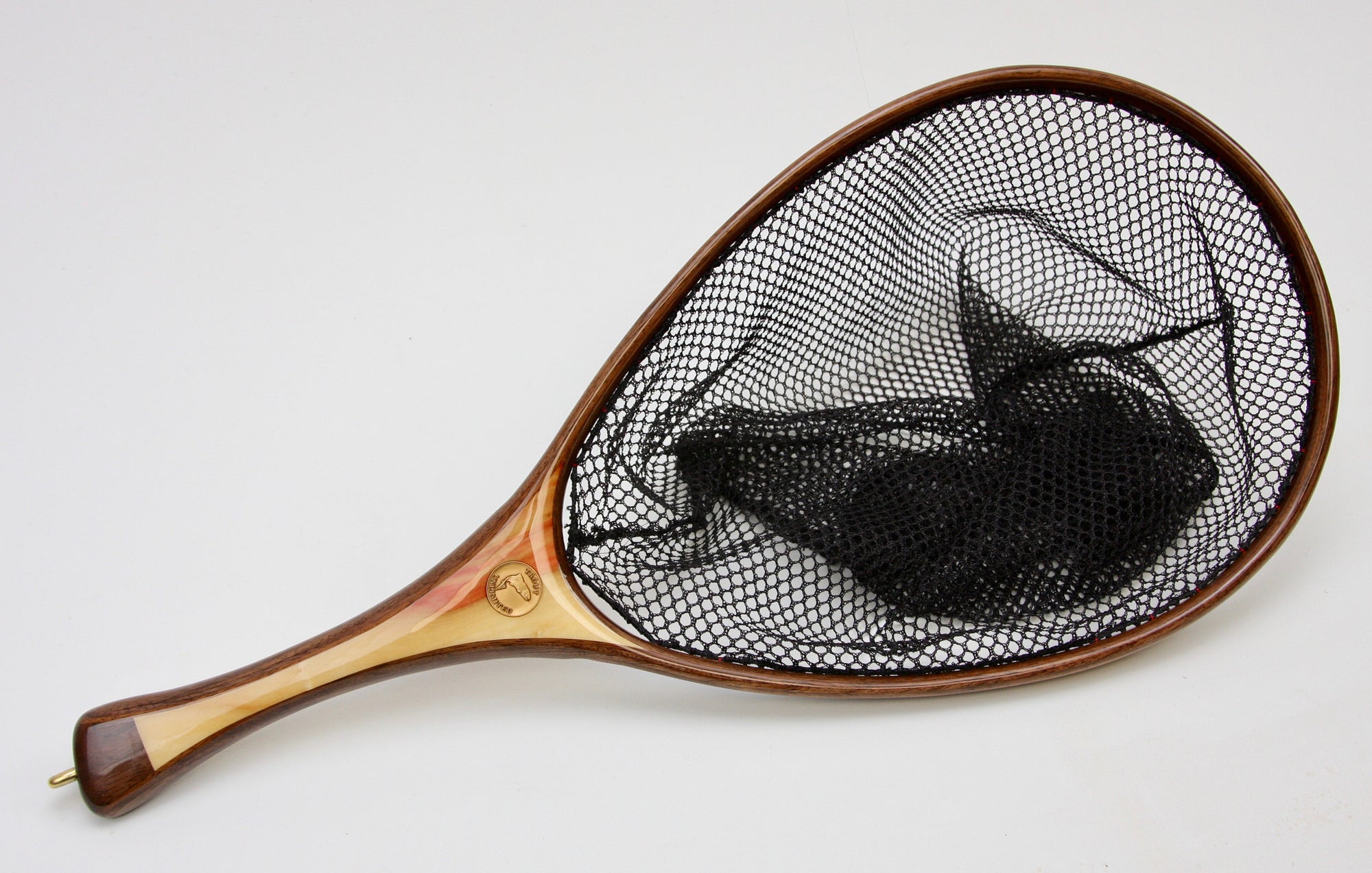 A fly fishing net with walnut hoop and handle of light wood.