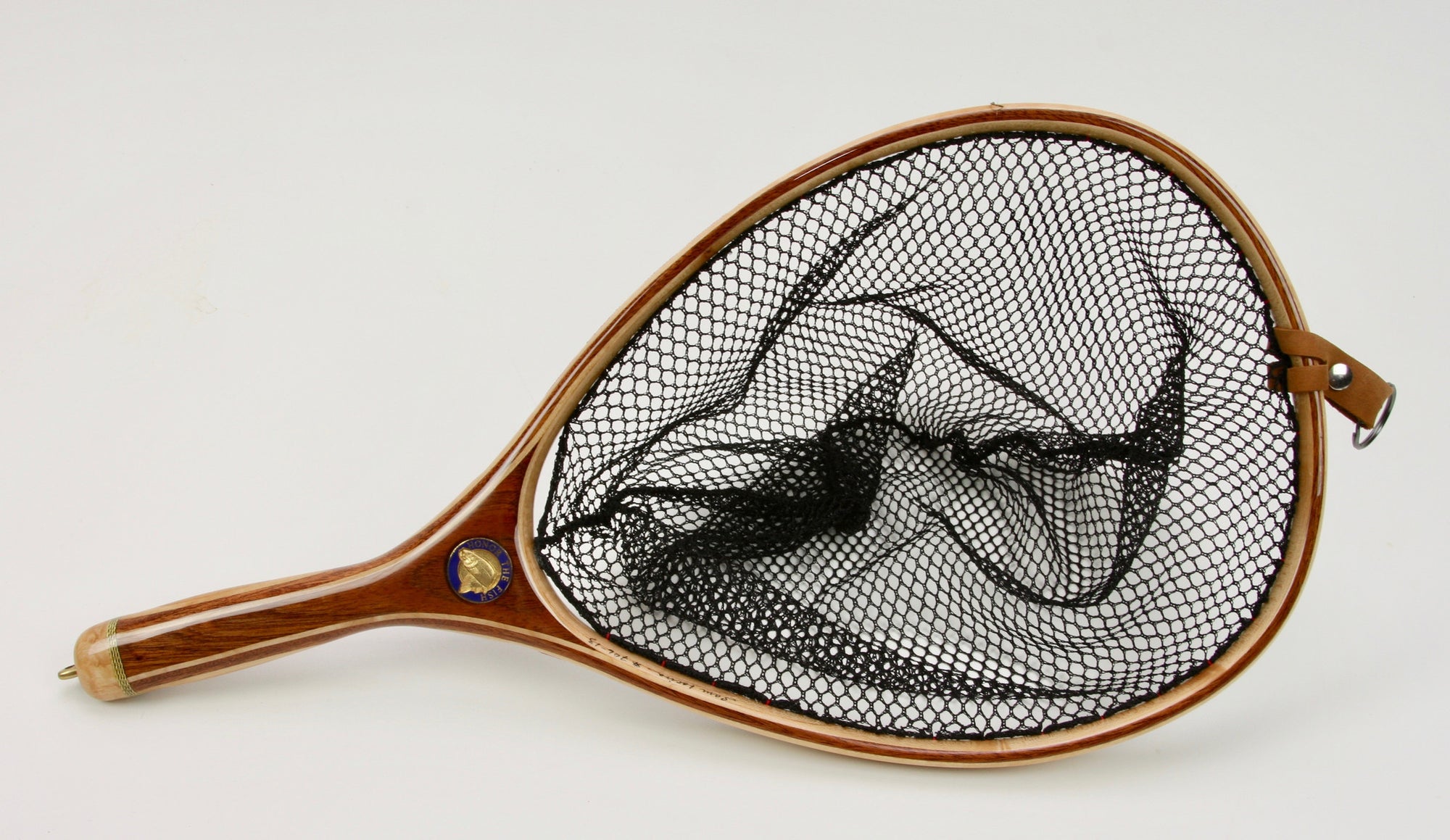 Wooden landing net with brown handle and medallion inset.