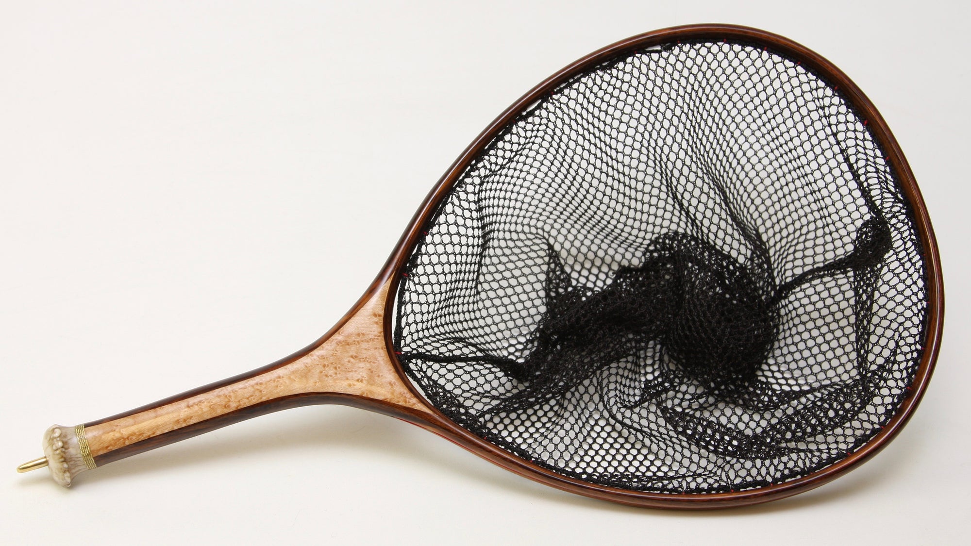 Landing net with dark frame and light colored handle. 