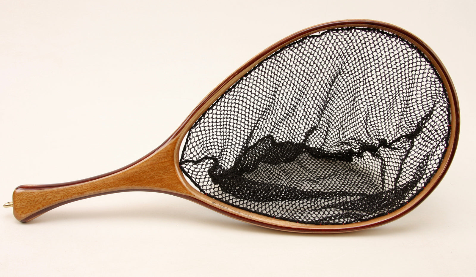 Fly fishing landing net with contrasting light and dark wood. 